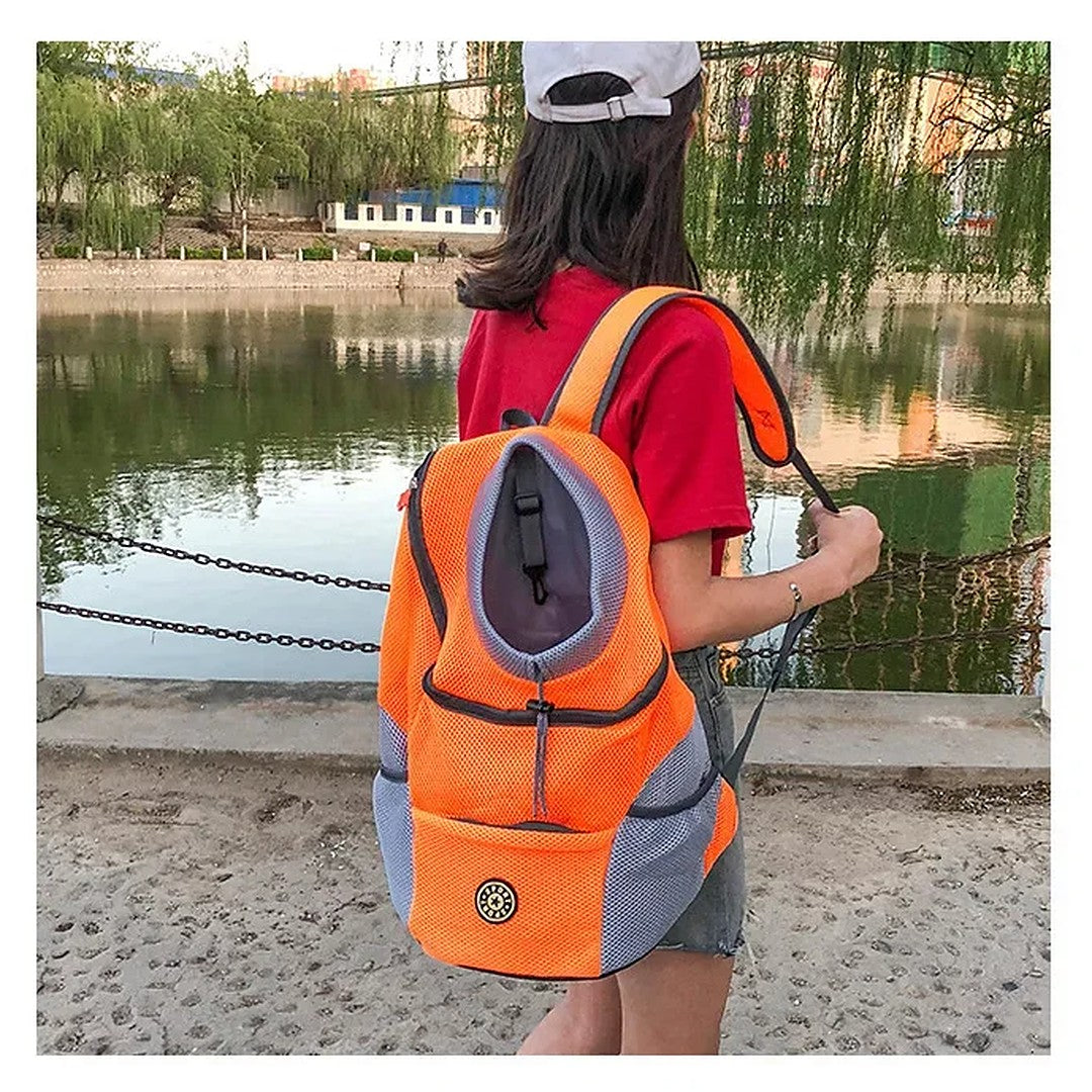 Mulher usando a mochila laranja nas costas em passeio à beira do lago