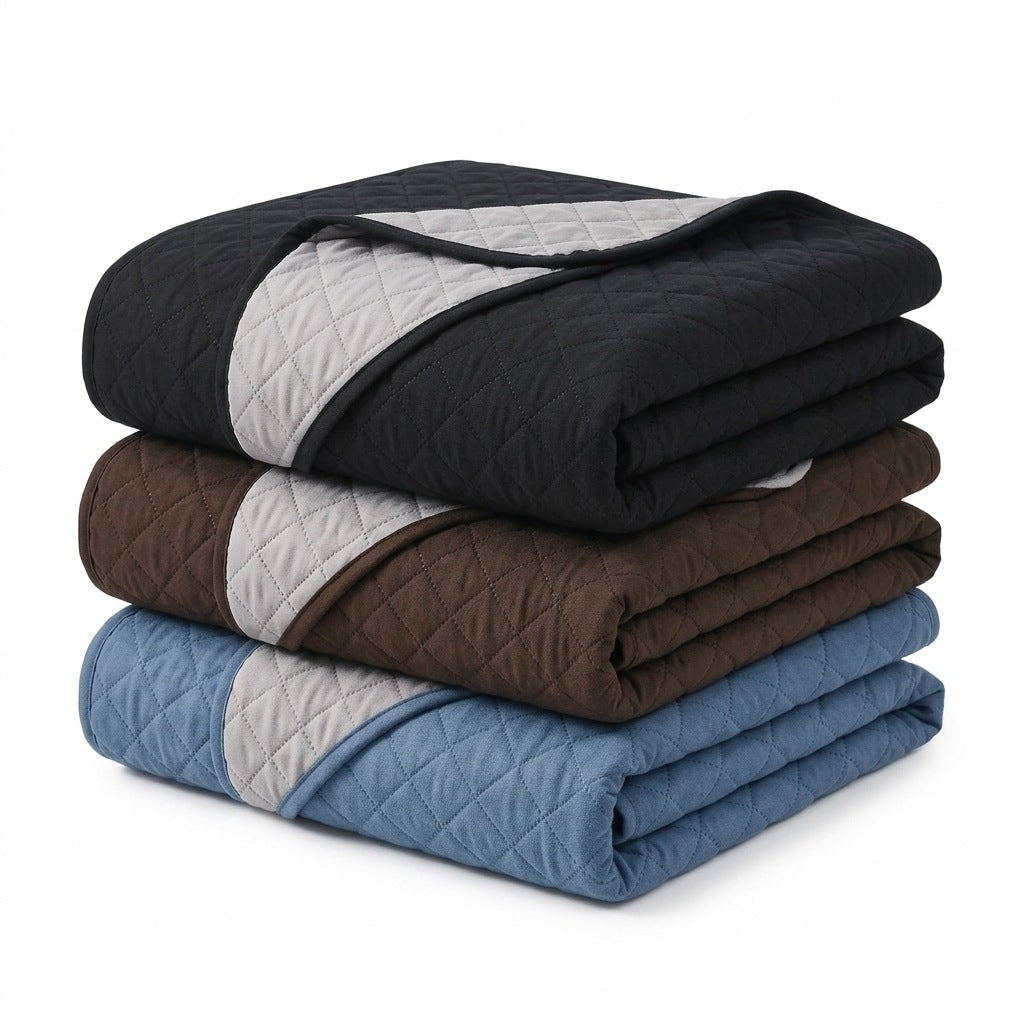 Mantas dobradas nas cores preto, marrom e azul com verso cinza claro